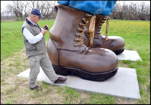 Travel writer Jim Winnerman takes a picture of his foot next to Paul Bunyan's foot at the Nathan Manilow Sculpture Park. 